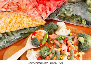 Frozen vegetables on cutting board and plastic bags - Shutterstock ID 330074270