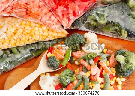 Frozen vegetables on cutting board and plastic bags