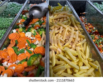 Frozen Vegetables: Potatoes, Carrots, Broccoli, Peas In A Supermarket Freezer.