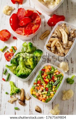 Frozen vegetables. Stocks of food for the winter. Container with frozen vegetables and mushrooms.