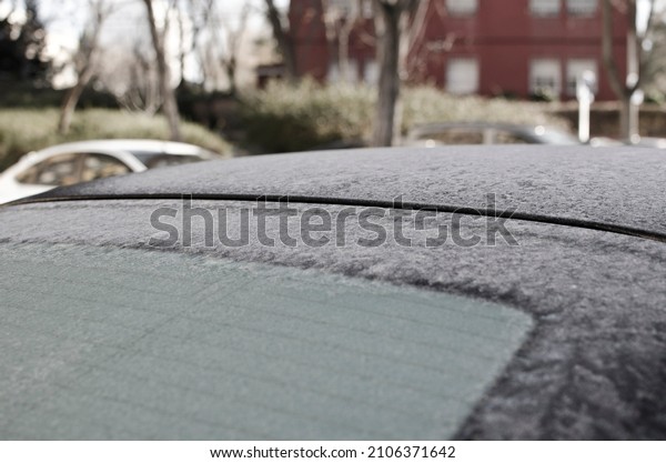 Frozen water in a car window in winter\
early in the morning, under below degrees\
weather.