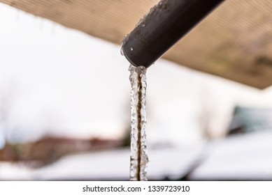 Frozen Water Flowing From The Roof Through A Plastic Pipe With A String Inside.