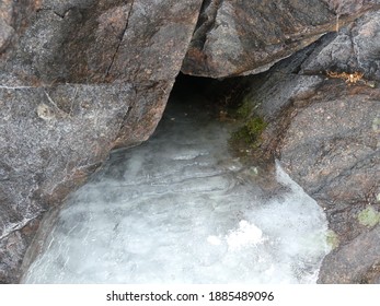 a frozen waterfall between rocks