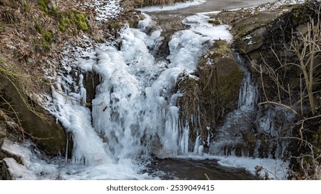 Frozen waterfall cascading through winter landscape with ice formations near a forest in the late afternoon
 - Powered by Shutterstock