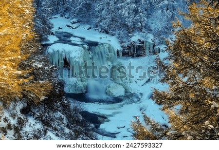 Frozen waterfall in the mountains. Winter frozen waterfall. Frozen waterfall in winter. Frozen waterfall in snow