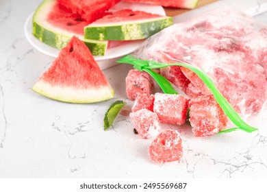 Frozen watermelon slices, cubes in freezing bags with fresh ripe raw watermelon on kitchen white table, Healthy simple canning, freezing stock up of fruit harvest for winter concept.  - Powered by Shutterstock