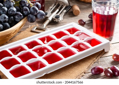 Frozen wine. Wine in ice cube tray on a rustic wooden table. - Powered by Shutterstock