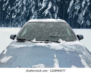 Frozen Winter Car Covered Snow In Forest, View Front Window Windshield And Hood On Snowy Background