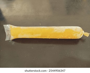 Frozen Yellow Ice Pop in Plastic Wrapper