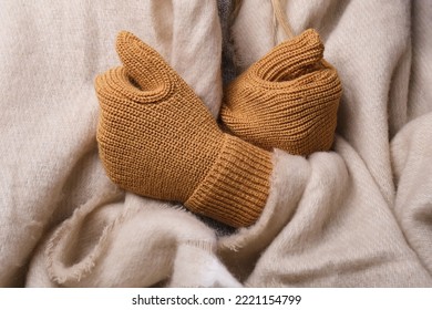 Frozen. A Young Woman Sits On The Floor In An Apartment In A Warm Sweater, Plaid And Mittens And Is Shivering From The Cold.