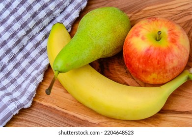 Fruit Apple Pear and Banana on a cloth and wood background