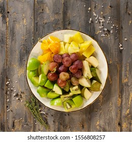 fruit apples and pears and pineapple on plate and wooden background