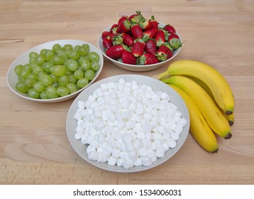 Fruit (Bananas, Grapes, Strawberries) And Marshmallows Ready For Grinch Fruit Kabobs On Wood