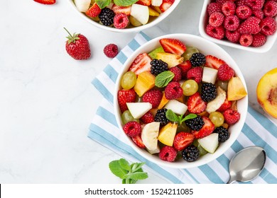 Fruit And Berry Salad In White Bowl, Top View, Copy Space