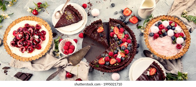 Fruit and berry tarts dessert on grey backgrond. Summer dessert concept.   Perfect for party. Top view, copy space, panorama, banner