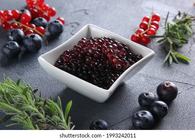 Fruit Black Caviar In A White Bowl With With Red Currant, Blueberry And Rosemary On A Gray Background. Background Image, Copy Space