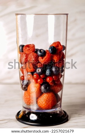 Fruit in a blender, mixer. Fruit cocktail and healthy food and drinks. Strawberry, raspberry, blueberry. Diet and vitamins for health, nutrition, smoothie diet