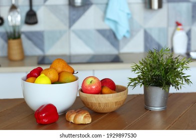 fruit in bowl still life with pot plant, paprika and croissant on the table close up photo on blue kitchen background - Powered by Shutterstock