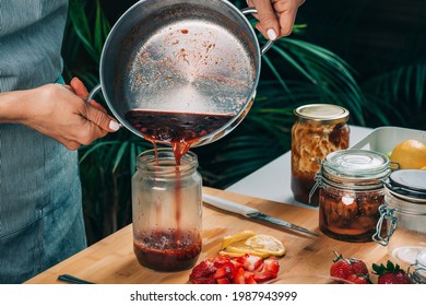 Fruit canning at home. Woman pouring cooked jam into sterile jars. Fruit preservation.