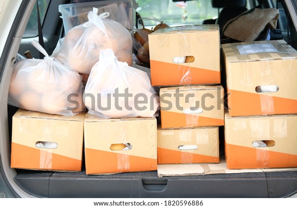 fruit in cardboard box & bag on car. food\
delivery service from\
farm