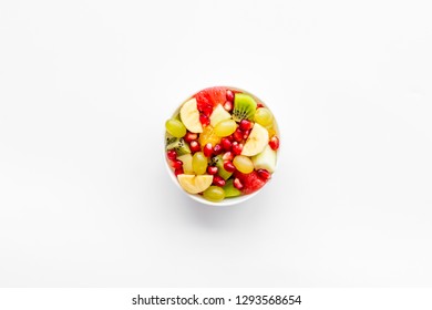 Fruit diet concept. Fruit salad with apple, kiwi and pomegranate in bowl on white background top view space for text - Shutterstock ID 1293568654