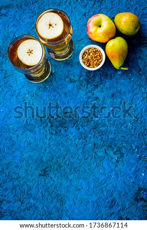 Fruit drinks with apple and pear on blue background from above copy space