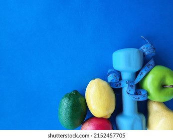 Fruit Dumbbell And Centimeter On Advertising Banner On Blue Background. Health Food And Sport Concept