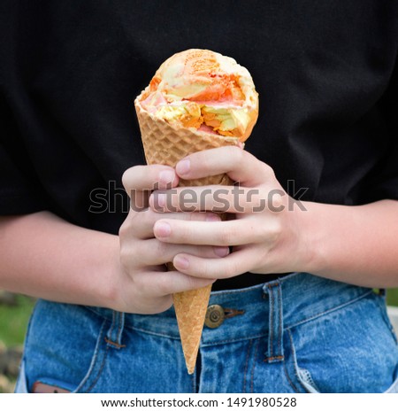 Fruit ice cream in the hands of a girl. Front view.  Close up
