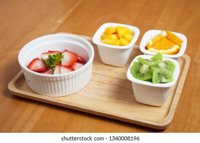 Fruit in the mini cup Starwberry, mango, orange and Kiwi, Fruit salad on the wood tray