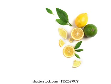 Fruit mix of lemon and lime on a white background with green leaves.