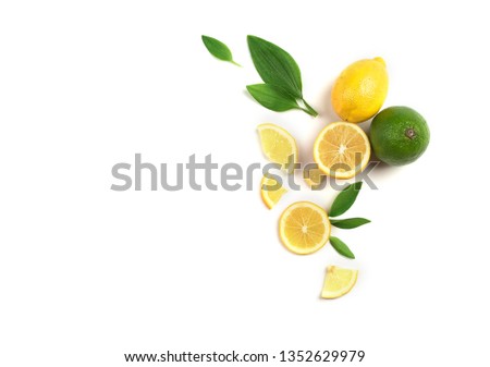 Fruit mix of lemon and lime on a white background with green leaves.