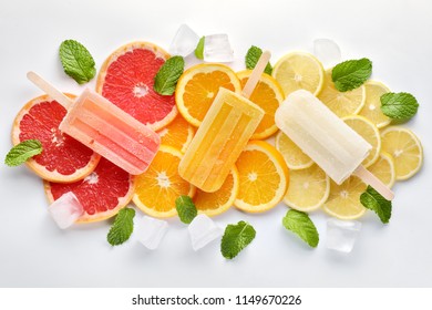 Fruit orange ice lolly, ice cubes and slices of orange on light blue background. Top view. - Powered by Shutterstock