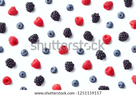 Fruit pattern of colorful wild berries isolated on white background. Raspberries, blueberries and blackberries. Top view. Flat lay
