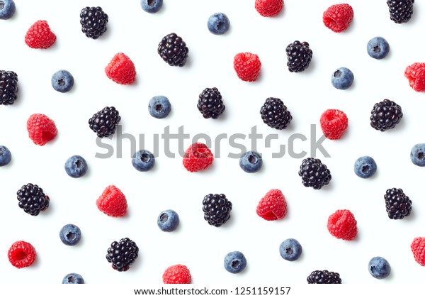 Fruit pattern of colorful wild berries isolated on\
white background. Raspberries, blueberries and blackberries. Top\
view. Flat lay