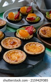 Fruit pies, egg tarts and Portuguese egg tarts on wooden board