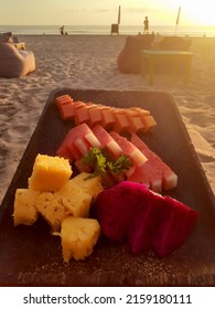 Fruit Plate On The Beach. The Fresh Tropical Fruit On The Beach. Plate With Fruits On The Tropical Sea Background. The Fresh Tropical Fruit On The Plate. Plate With Fruits On The Wooden Table.