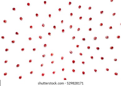 Fruit pomegranate seeds scattered in a chaotic manner, isolated on white background. Food background.