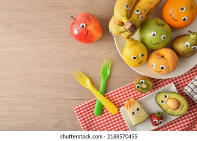 Fruit Prepared And Attractively Decorated With Eyes And Mouths To Motivate Children's Healthy Eating On Wooden Table Fruits And Vegetables Child Healthy Eating Concept. Top View.