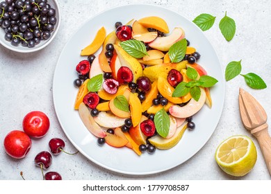 Fruit Salad With Berries In A White Plate, White Background. Healthy Vegan Food Concept.