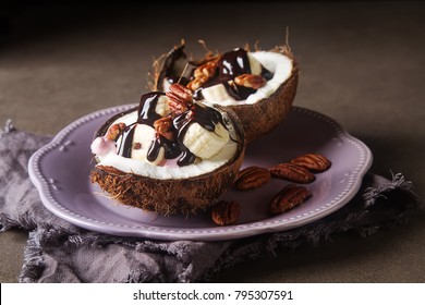 Fruit Salad With Coconut, Banana, Yogurka Drizzled With Hot Dark Chocolate. Dark Background