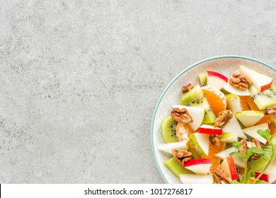 Fruit Salad Of Fresh Sweet Apple, Pear, Tangerine And Walnuts. Healthy Vegetarian Food