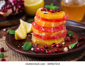 Fruit salad with grapefruit and orange, pomegranate seeds, honey and lemon, decorated with mint - Powered by Shutterstock