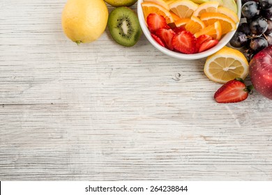 Fruit Salad With Ripe Fruits On Wooden Table