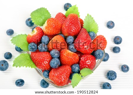 Bowl with red berries and mint leaves