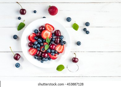 Fruit salad with strawberries, blueberries and sweet cherries. Top view, flat lay - Powered by Shutterstock