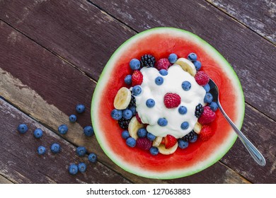 Fruit salad topped with yogurt in carved watermelon