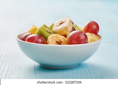 Fruit Salad In White Bowl On Wooden Blue Table