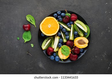 Fruit Summer Bowl. Orange, Kiwi, Cherry, Spinach Blueberry Apricot Plate Top View