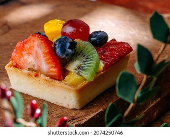 Fruit Tart On Wooden Table. Contains Strawberry, Mandarin, Blueberry And Kiwi.