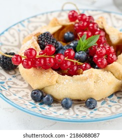 Fruit Tart With Red Currants Sprinkled With Powdered Sugar On A White Table